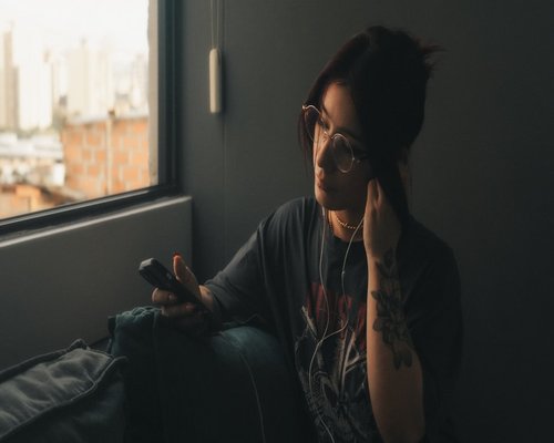 Woman looking out the window, taking a break from her digital devices